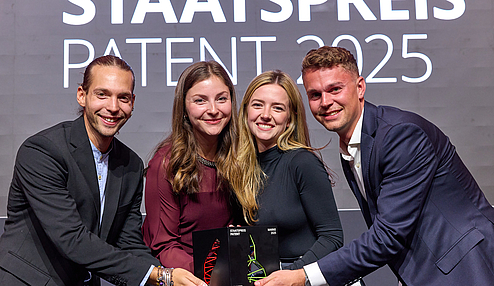 Neworn beim Staatspreis Patent 2025 mit Trophäe auf der Bühne